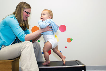 Janet Hauck holds son Charlie, 9 months, on a pediatric treadmill, which was designed to see if babies at risk for obesity that have more physical activity early in life have a changed weight trajectory as they age.