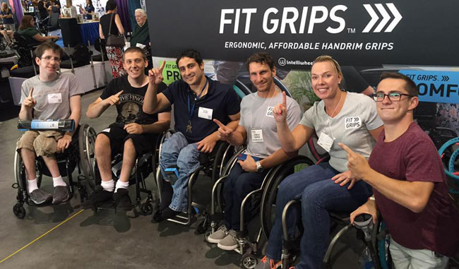 MSU Kinesiology graduate Marissa Siebel-Siero promotes her company alongside wheelchair racer Josh George (to her right) and members of a youth sled hockey team.