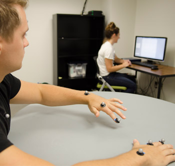 Student assistants in the motor learning and rehabilitation engineering lab use equipment to analyze movements.