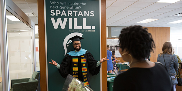 Graduate smiles after graduation. Who will inspire the next generations? Spartans will. 