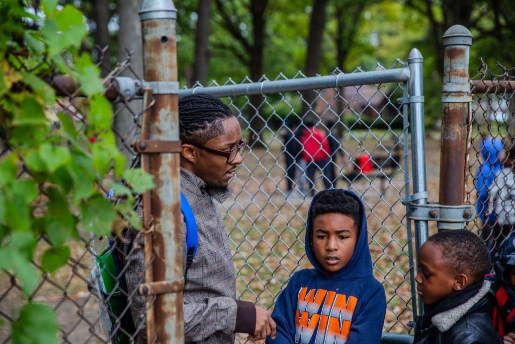 Mario Lemons speaks with a group of students outdoors.