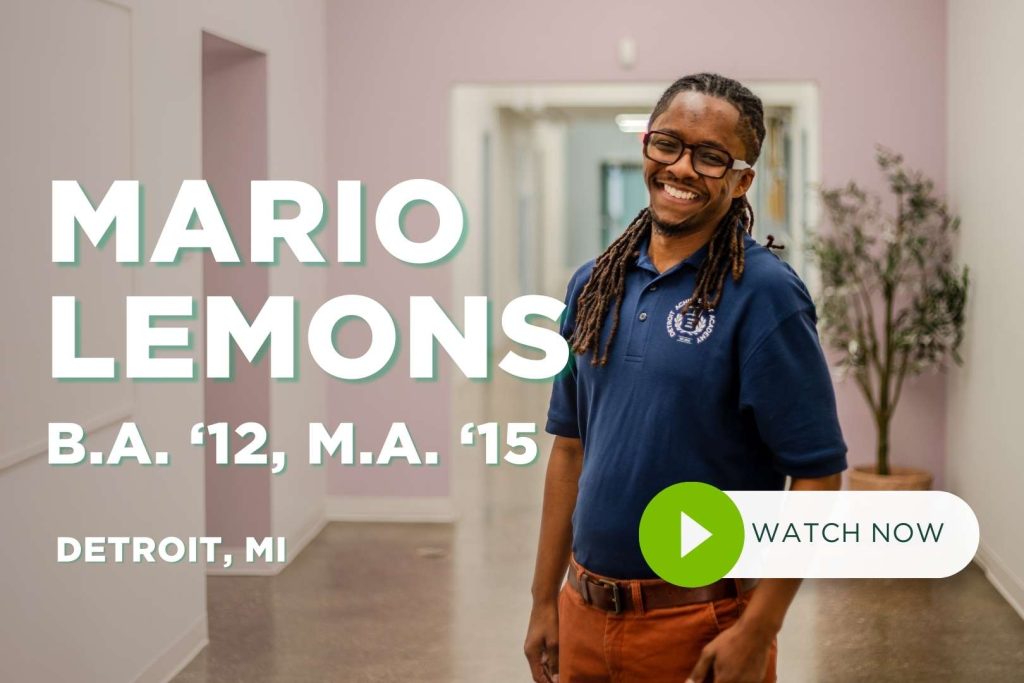 Mario Lemons stands in hallway with arms at his side, smiling at camera.