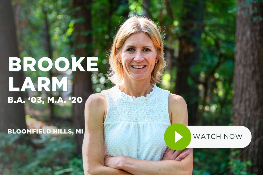 Brooke Larm stands in outdoors smiling at camera with arms crossed.