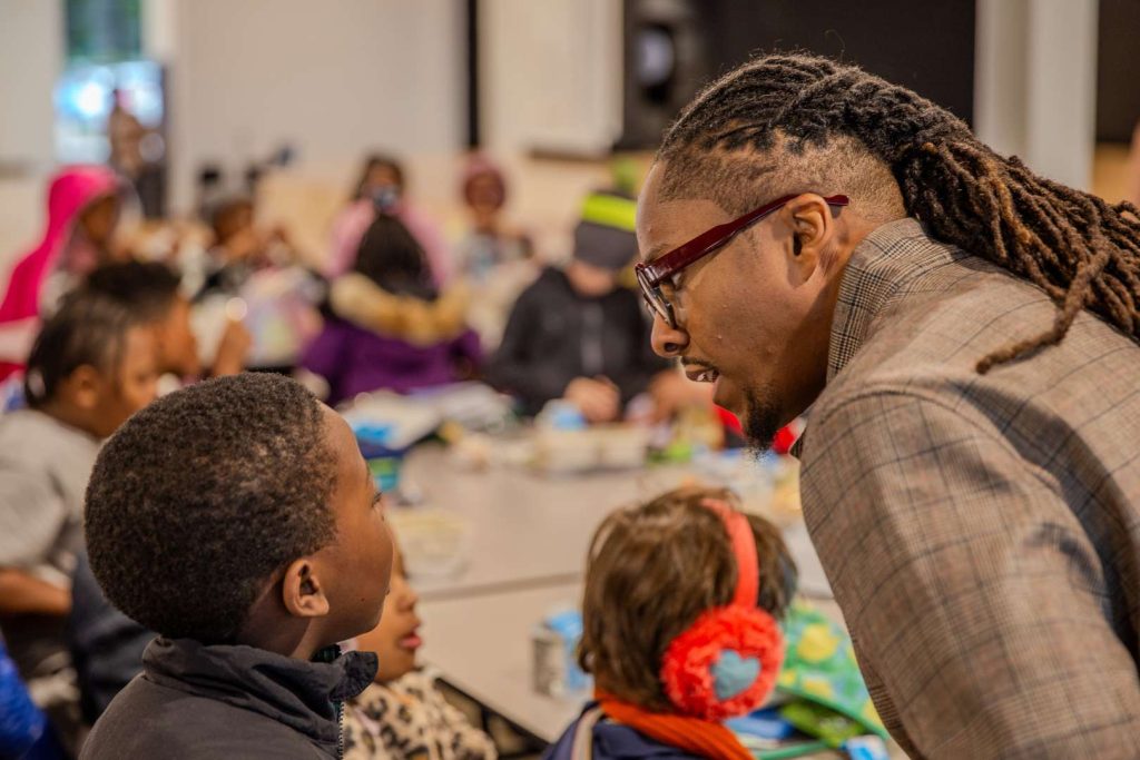 Mario Lemons speaks with a student in the lunchroom. 