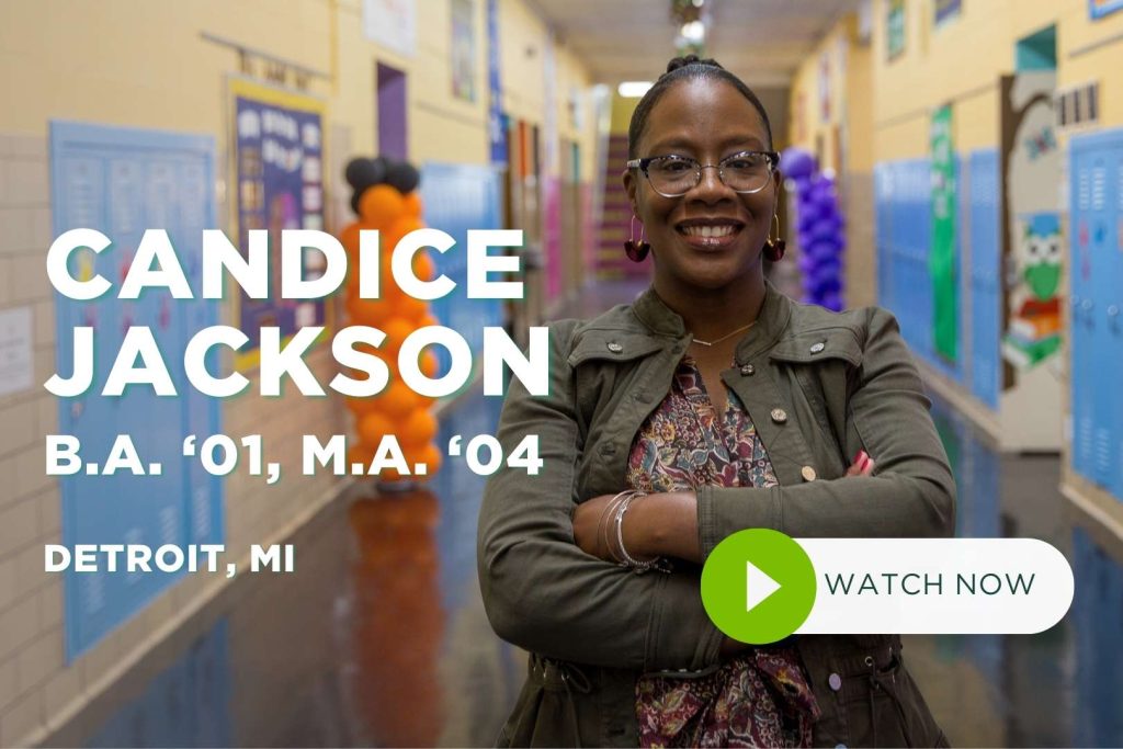 Candice Jackson stands in hallway smiling at camera with arms crossed.