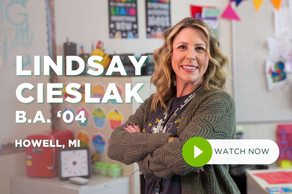 Lindsay Cieslak stands in classroom smiling at camera with arms crossed.