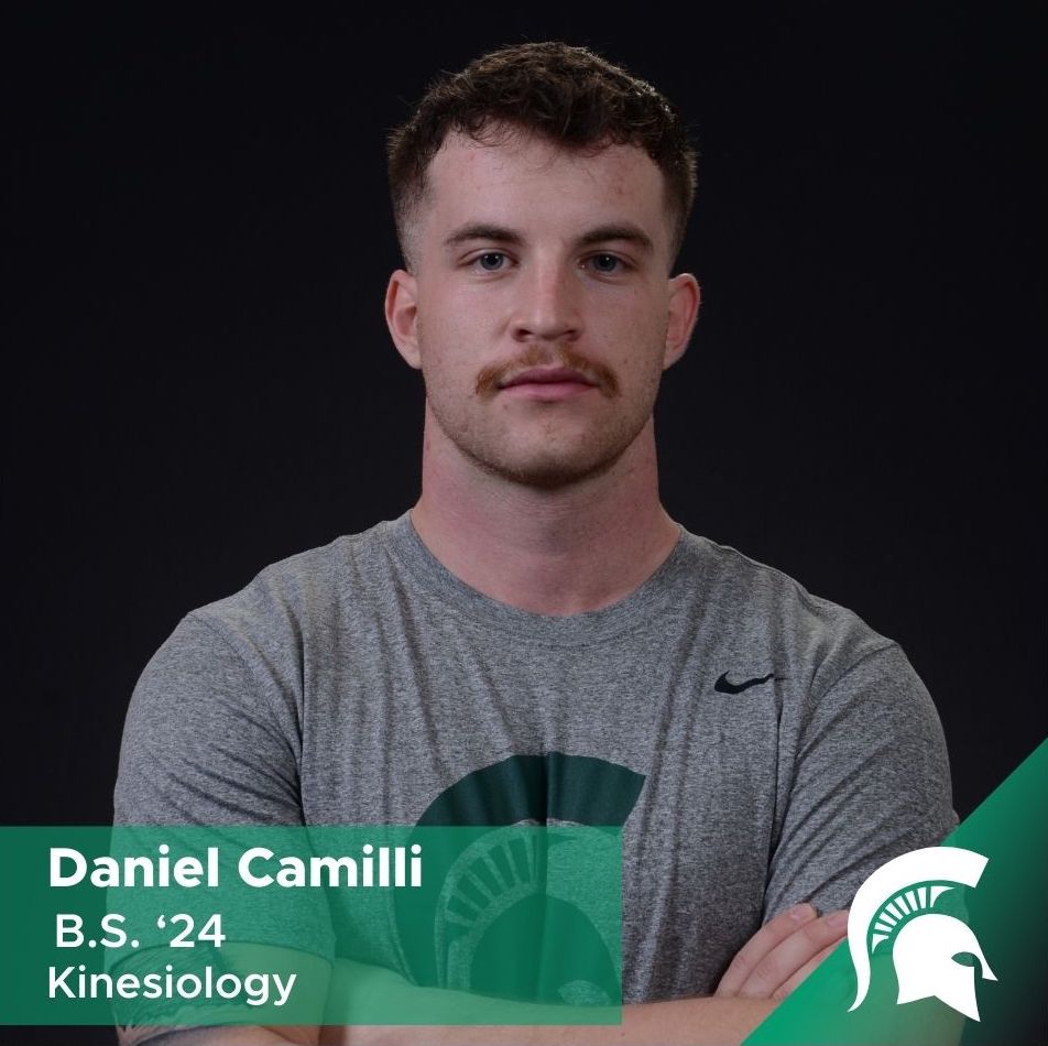 Photo of Daniel Camilli looking directly into the camera with his arms crossed. He is wearing a shirt with a Spartan helmet on it.