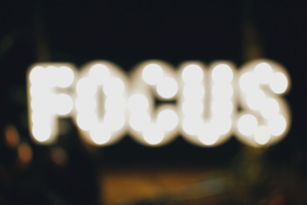 This is a picture of the word "focus" illuminated. The word focus appears out of focus and blurry.