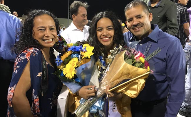 Alvarez pictured with her parents, Martha (left) and Eddie (right)