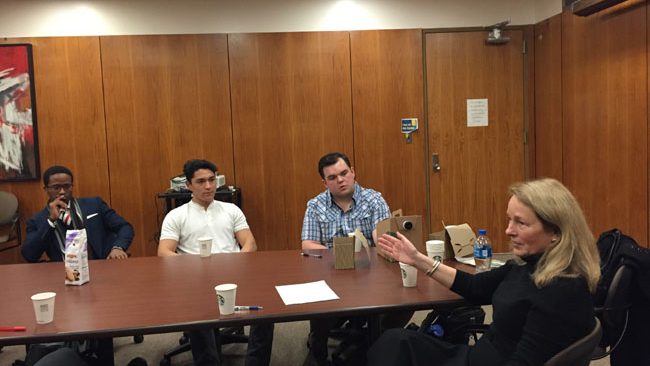 Ann Hiller speaking with students at a conference table during a Venture Capital and Private Equity class. 