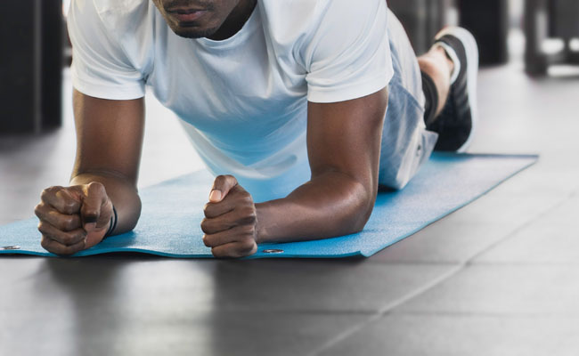 Stock Photo, Black male doing planking excersise in fitness gym, from Getty.