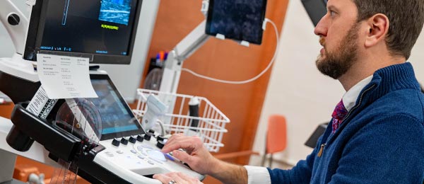 man looking at a medical computer and xray machine