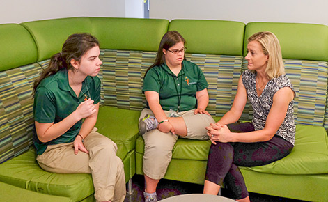 Marisa Fisher (far right) speaks with two Spartan Project SEARCH interns. 