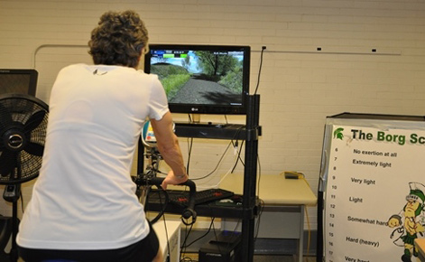 Adult on exercise bike and video game screen