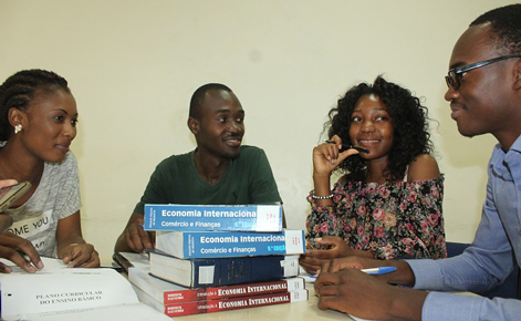 University students around a table with books
