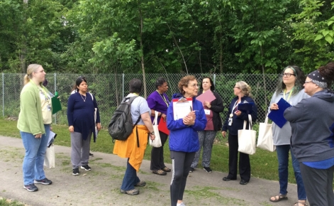 Professor Gail Richmond stands outdoors with a group of educators on a trail.