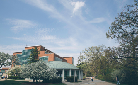 A river-view shot of Erickson Hall on a sunny, spring day. The Kiva can be seen in the front of the shot.